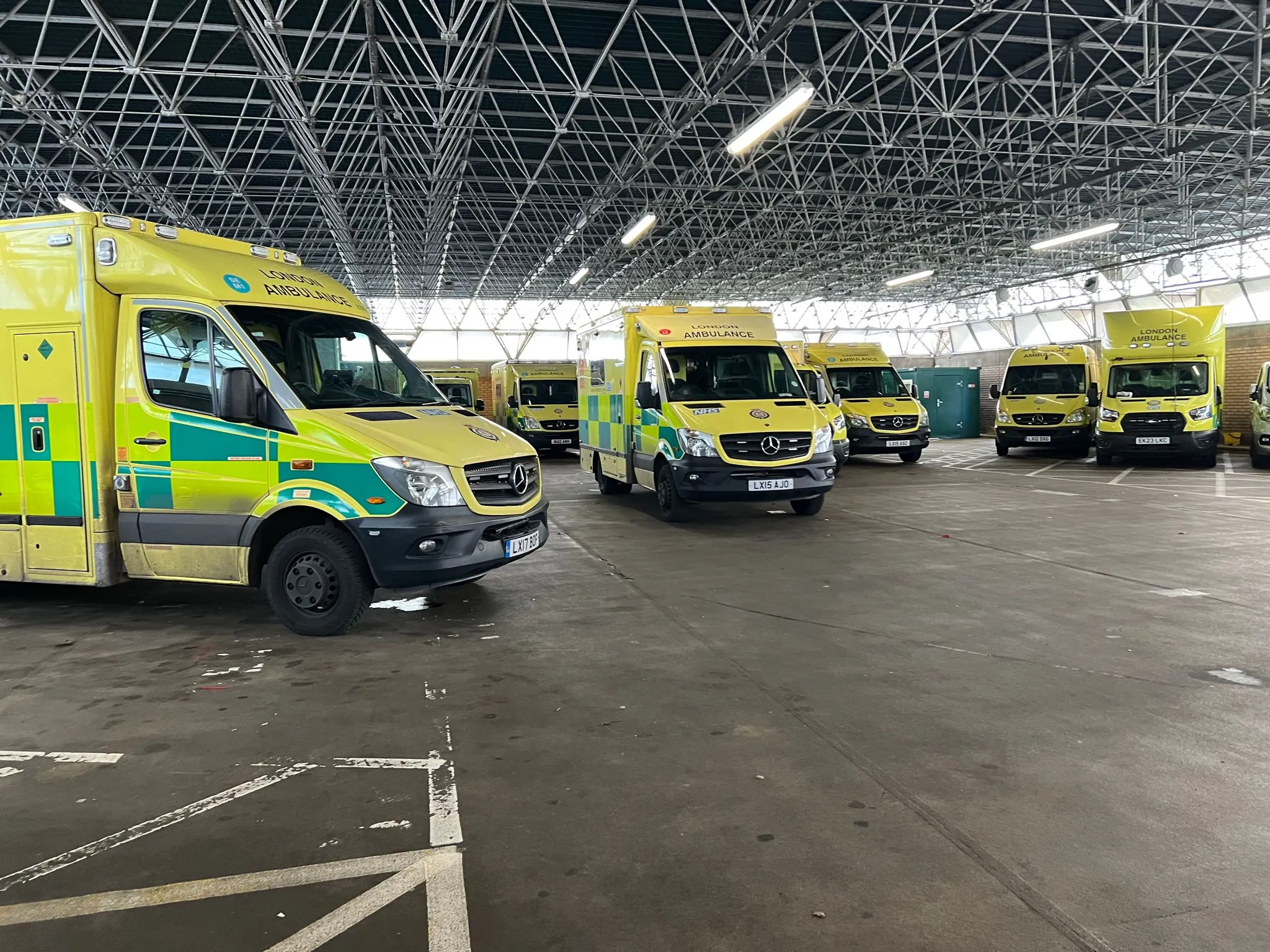 A group of ambulances parked inside of a building.