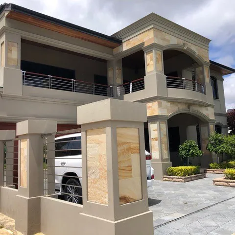 A car parked in front of a two story house.