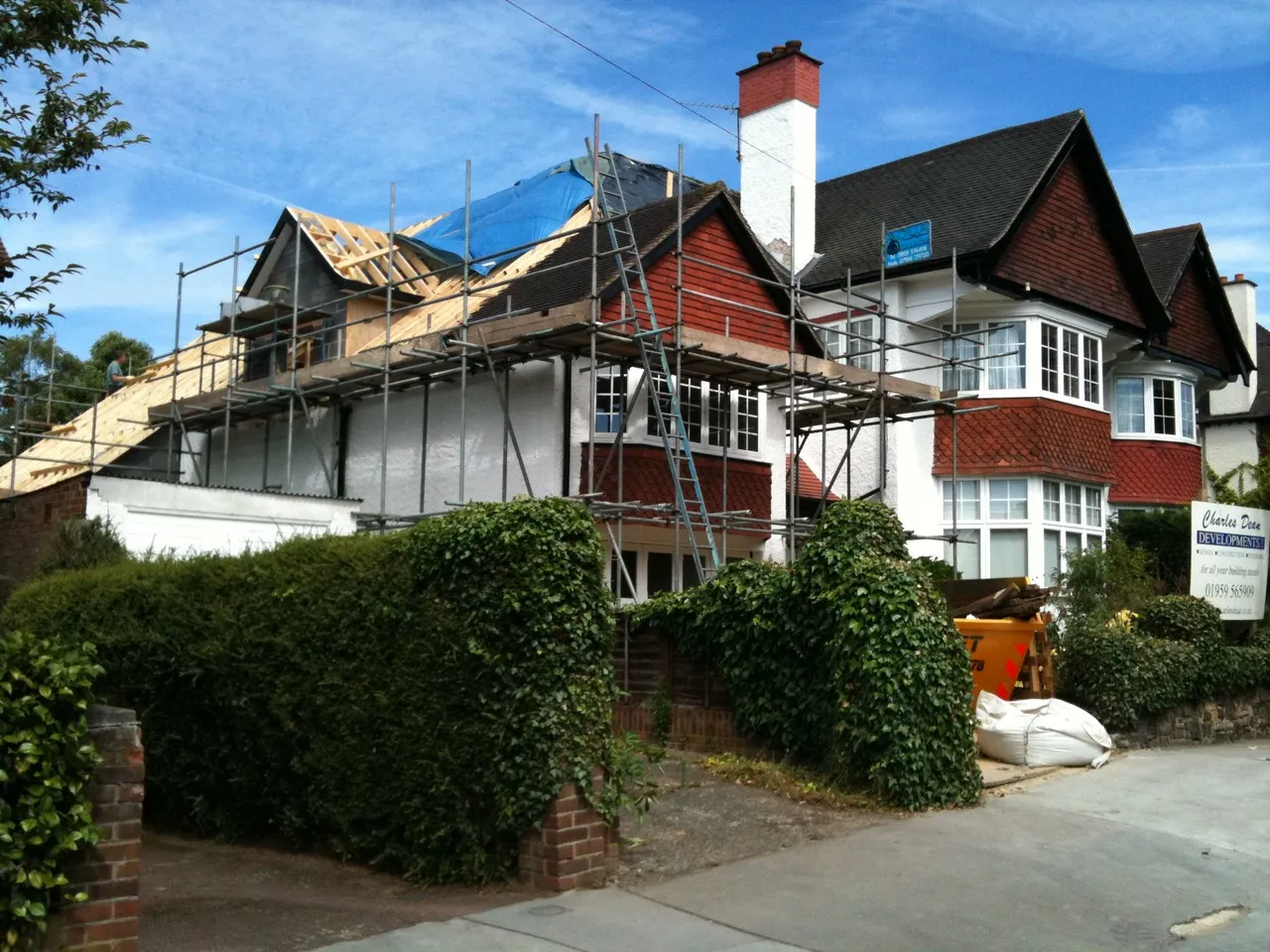 A house under construction with scaffolding on the roof.