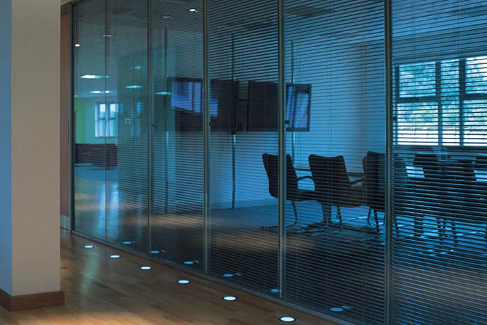 A room with a glass wall and a television on the wall.